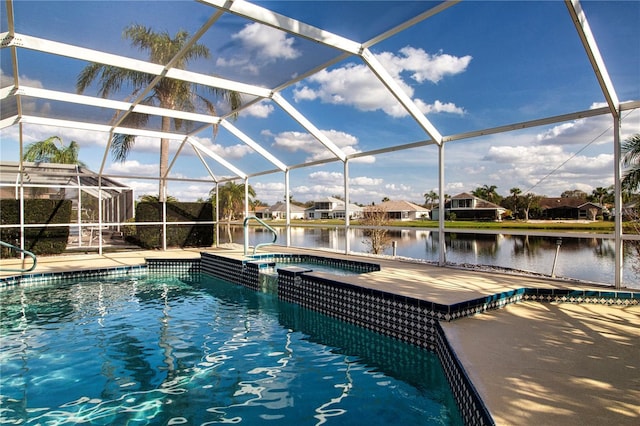 view of pool with a patio, a water view, a lanai, and a pool with connected hot tub