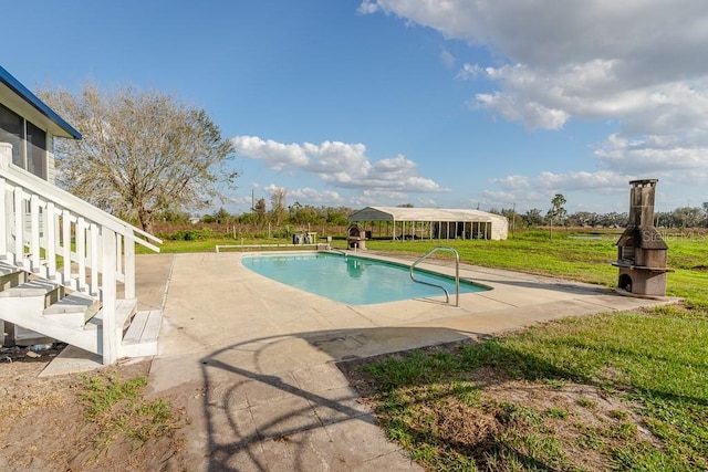 view of swimming pool with a yard and a patio area