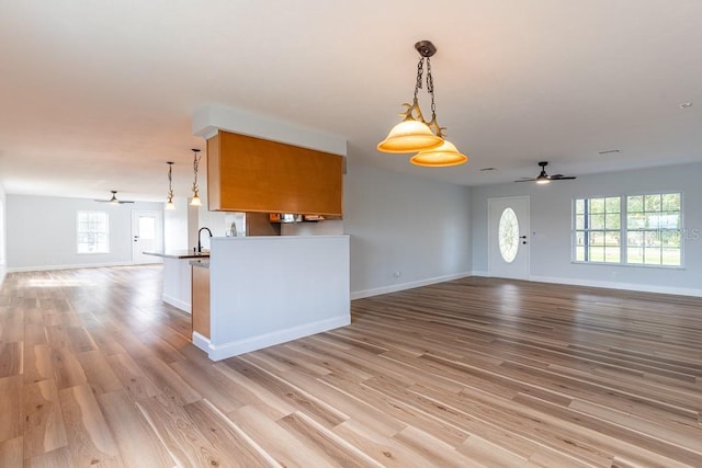 kitchen featuring pendant lighting, sink, light hardwood / wood-style floors, and ceiling fan