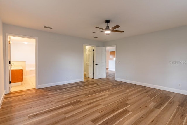 unfurnished bedroom with light hardwood / wood-style floors, ceiling fan, and ensuite bathroom