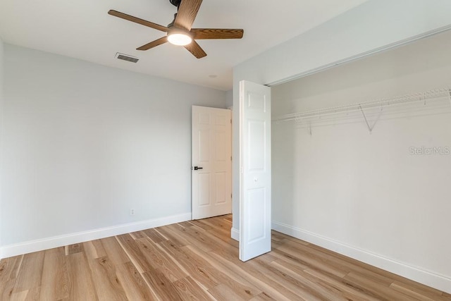 unfurnished bedroom featuring ceiling fan, a closet, and light wood-type flooring