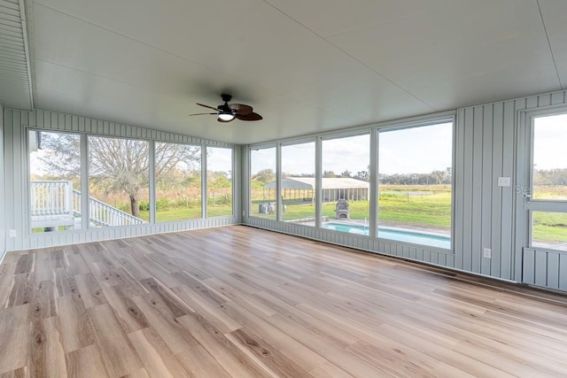 unfurnished sunroom featuring ceiling fan