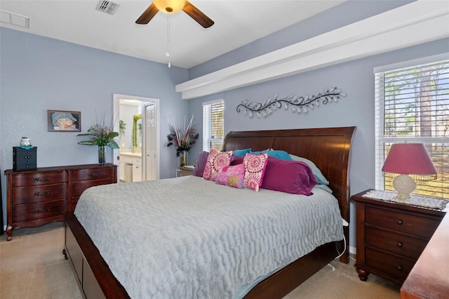 carpeted bedroom with ceiling fan and ensuite bath