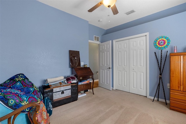 carpeted bedroom with ceiling fan and a closet