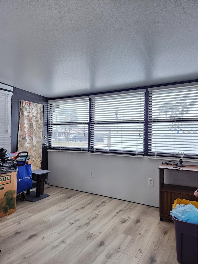 office area with light hardwood / wood-style floors and a textured ceiling