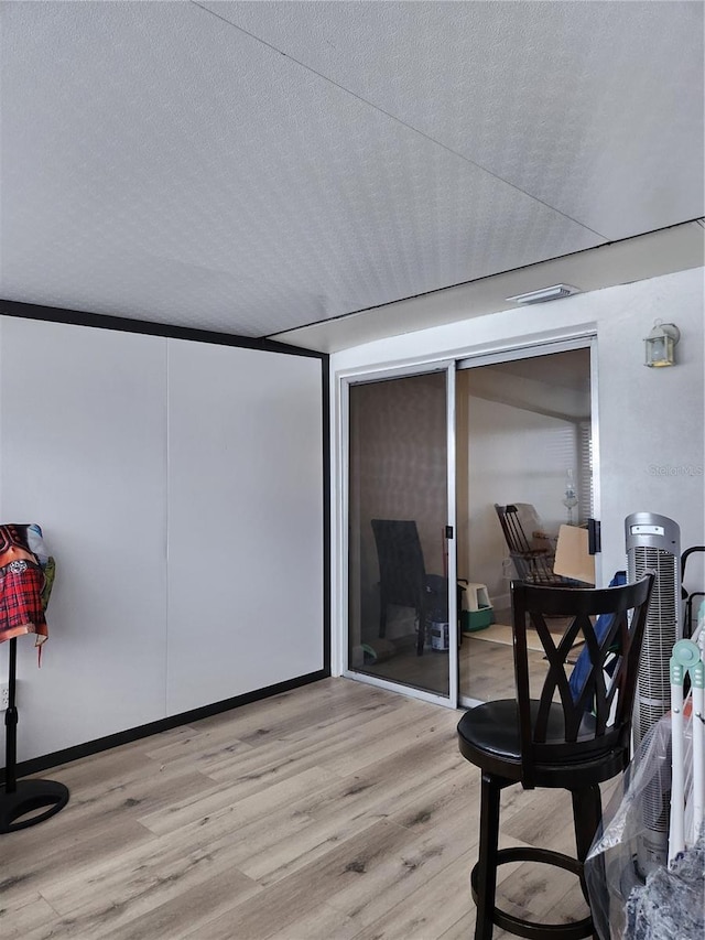 interior space featuring a textured ceiling and light hardwood / wood-style flooring