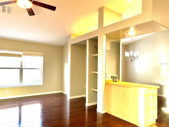 interior space featuring pendant lighting, lofted ceiling, dark hardwood / wood-style flooring, and ceiling fan with notable chandelier