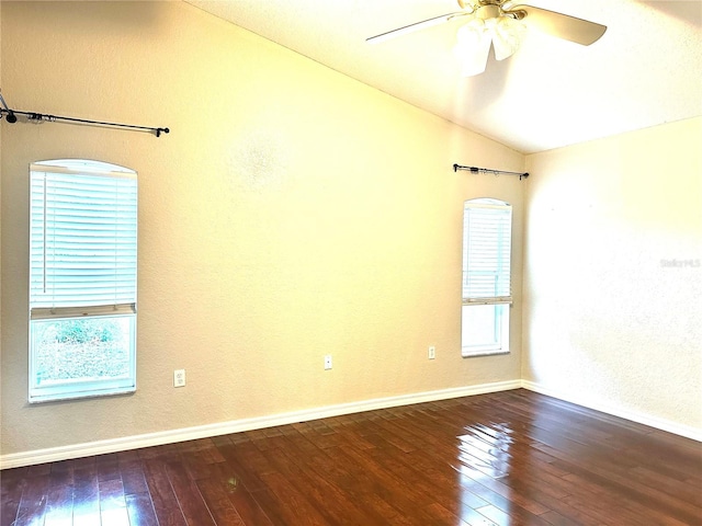 empty room with hardwood / wood-style flooring, plenty of natural light, and vaulted ceiling