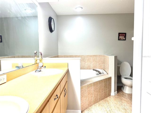 bathroom with tiled tub, vanity, tile patterned floors, and toilet