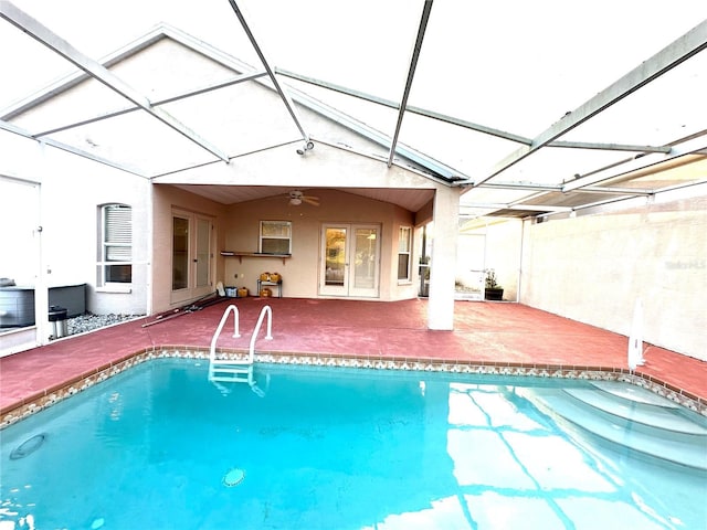 view of swimming pool with ceiling fan, a lanai, and a patio area