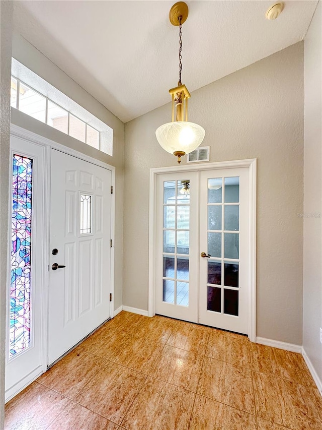 entryway featuring lofted ceiling and french doors