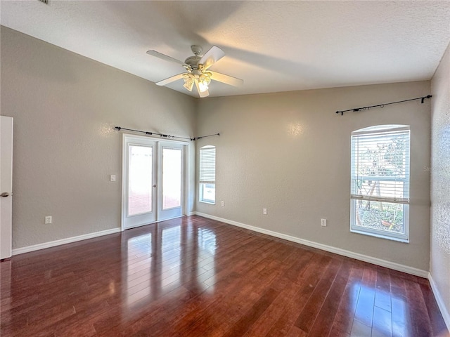 unfurnished room featuring a textured ceiling, dark wood-type flooring, french doors, and ceiling fan