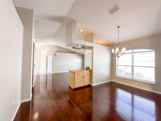 interior space featuring lofted ceiling, dark wood-type flooring, and ceiling fan with notable chandelier