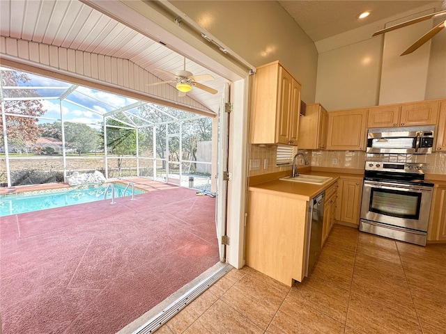 kitchen featuring sink, tasteful backsplash, light brown cabinets, ceiling fan, and stainless steel appliances