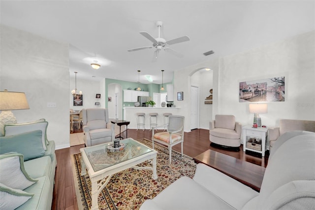 living room featuring hardwood / wood-style floors and ceiling fan with notable chandelier