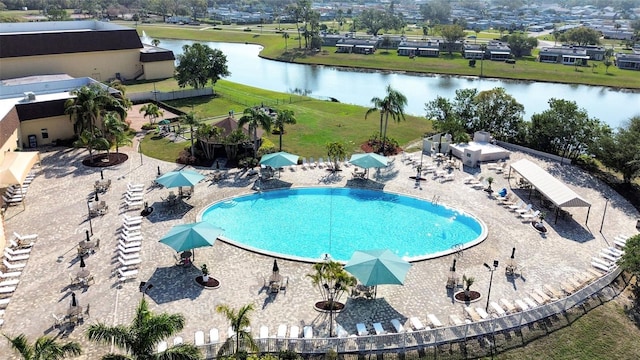 view of swimming pool with a patio area and a water view