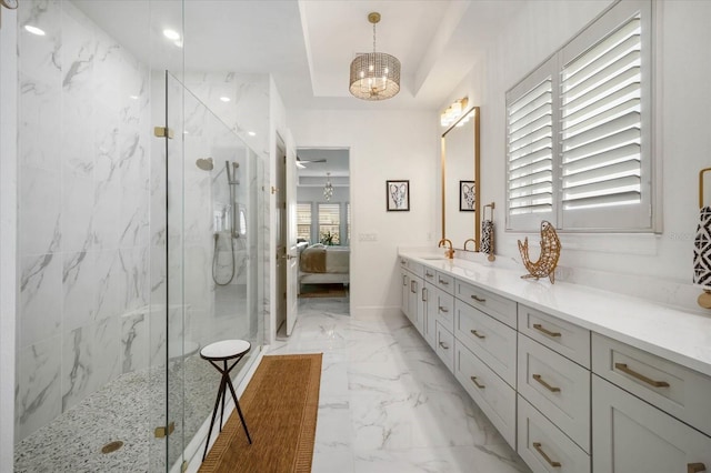 bathroom featuring vanity, a raised ceiling, and a tile shower