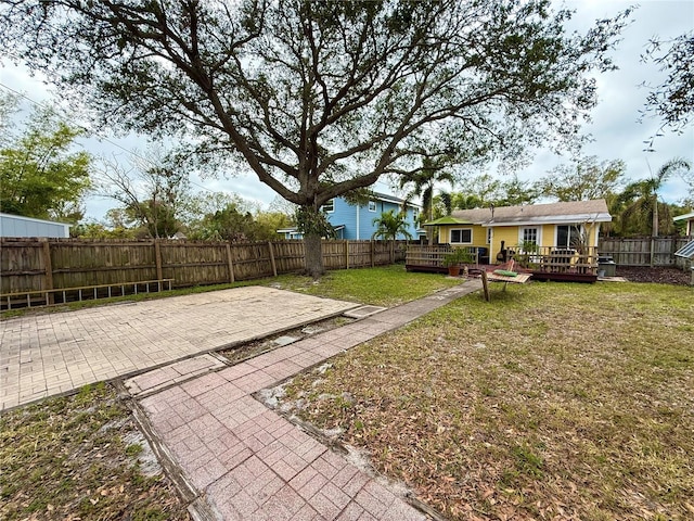 view of yard with a wooden deck and a patio