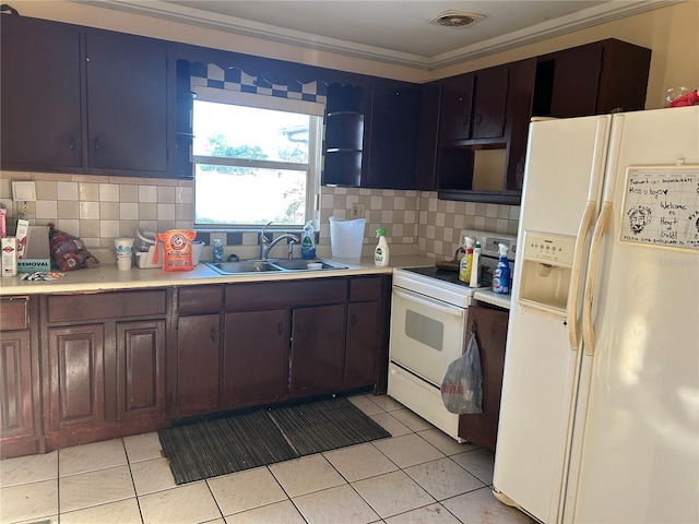 kitchen featuring dark brown cabinetry, sink, light tile patterned floors, and white appliances