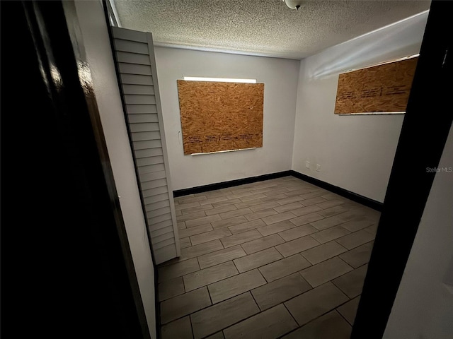 unfurnished room featuring a textured ceiling