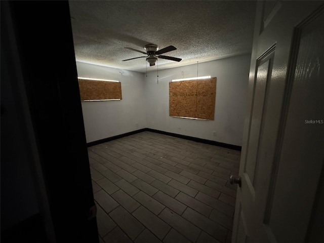 empty room featuring ceiling fan and a textured ceiling