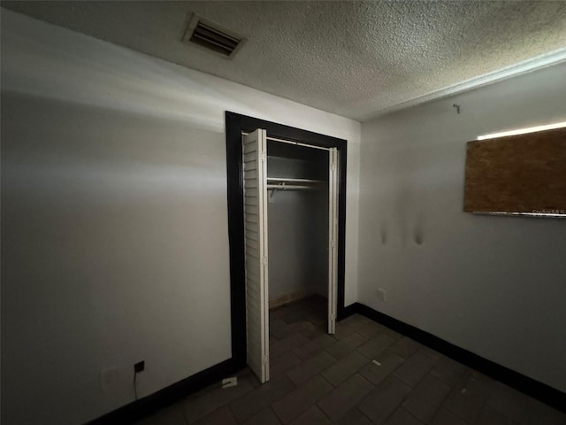 unfurnished bedroom with a textured ceiling and a closet