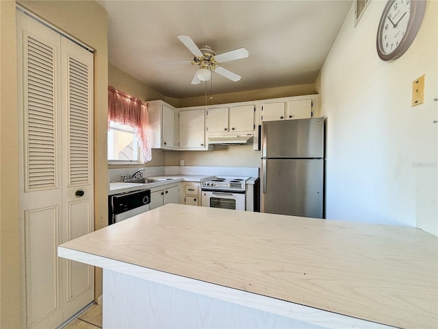 kitchen with appliances with stainless steel finishes, kitchen peninsula, sink, and white cabinets