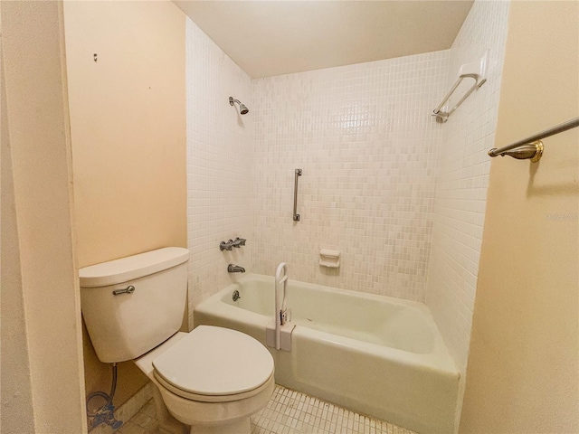 bathroom with tile patterned flooring, tiled shower / bath, and toilet