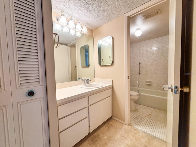 full bathroom featuring tile patterned flooring, tiled shower / bath combo, vanity, a textured ceiling, and toilet