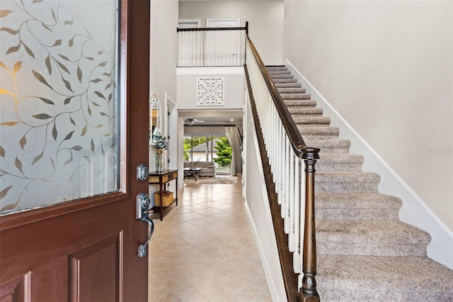 entrance foyer featuring a towering ceiling and light tile patterned floors