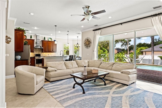 tiled living room with ceiling fan, ornamental molding, and sink