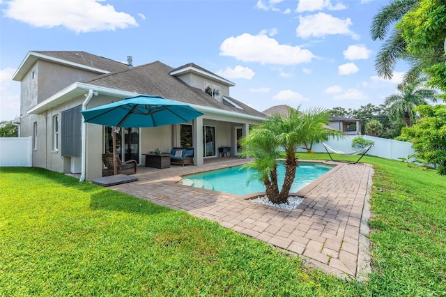 rear view of house featuring a yard, outdoor lounge area, a fenced in pool, and a patio area