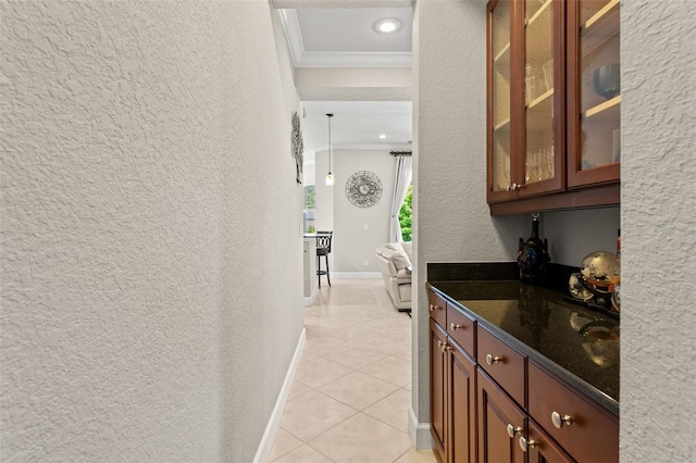 bar with crown molding, dark stone counters, and light tile patterned flooring