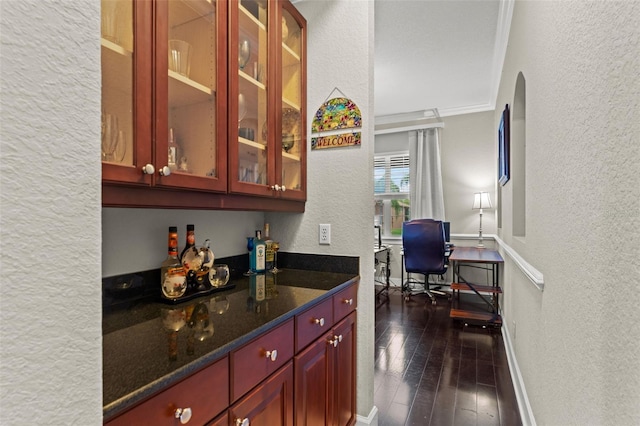 bar featuring dark stone countertops and dark wood-type flooring