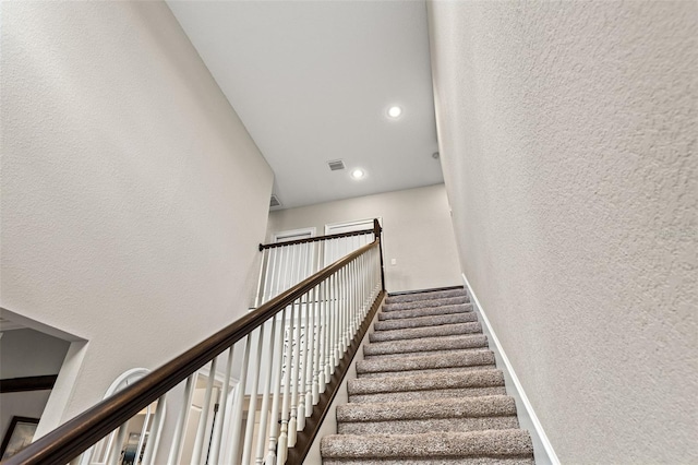 stairs featuring a towering ceiling