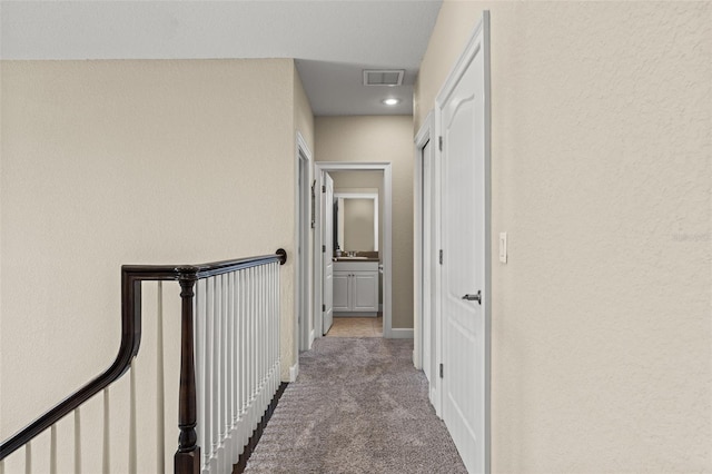 hallway with light colored carpet