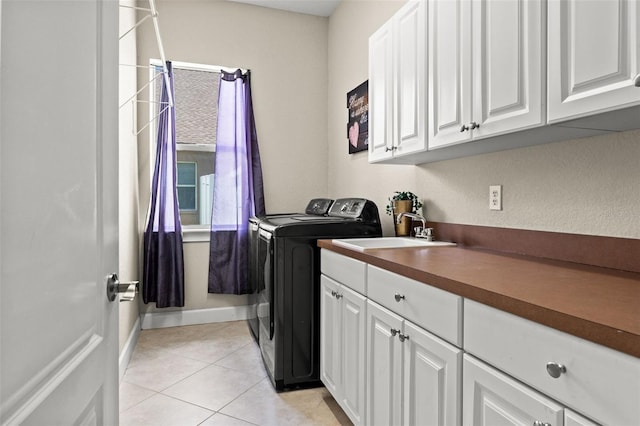 laundry area featuring cabinets, washer and clothes dryer, sink, and light tile patterned floors