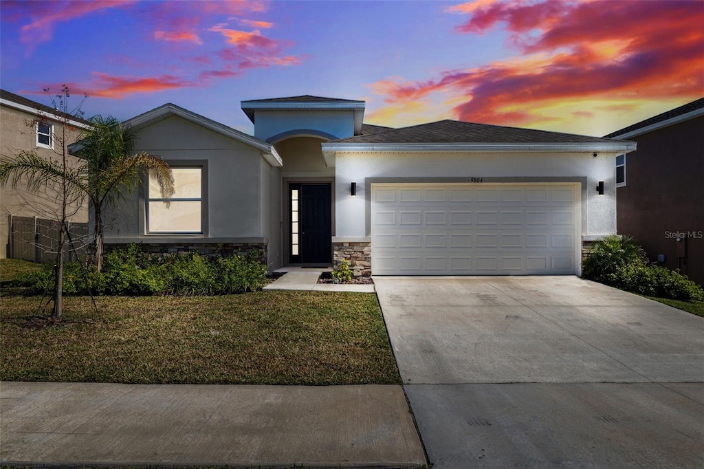 prairie-style home featuring a garage and a yard