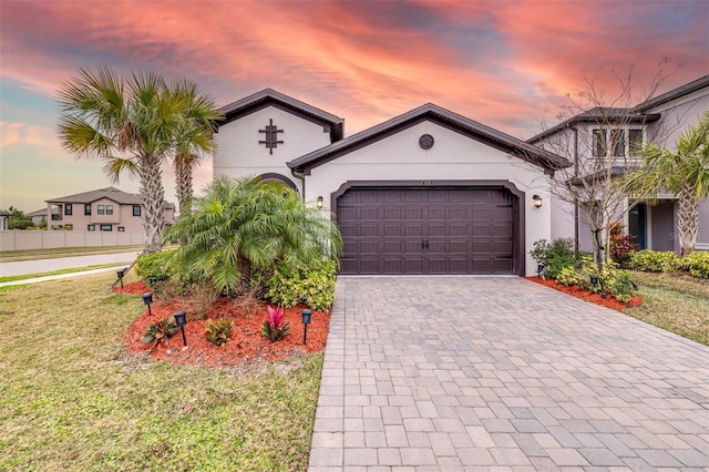 view of front of property with a garage and a yard