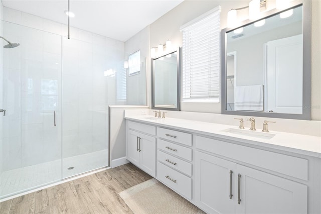 bathroom with vanity, wood-type flooring, and a shower with shower door