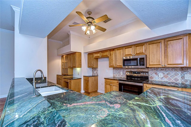 kitchen featuring appliances with stainless steel finishes, sink, backsplash, ceiling fan, and crown molding