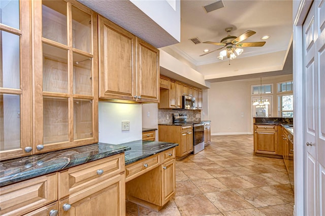 kitchen with appliances with stainless steel finishes, ceiling fan with notable chandelier, pendant lighting, dark stone countertops, and decorative backsplash