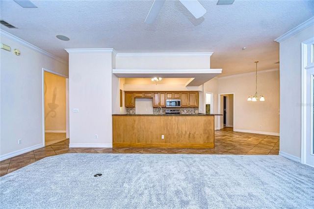 unfurnished living room with ornamental molding, ceiling fan with notable chandelier, and tile patterned floors