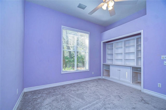 carpeted spare room with ceiling fan