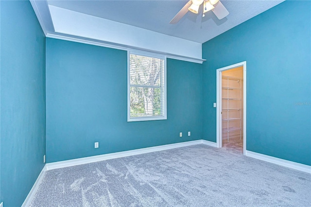 carpeted spare room with ceiling fan