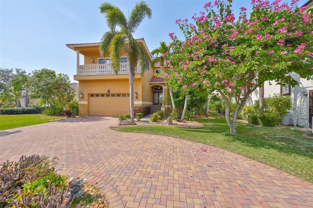 mediterranean / spanish house featuring a garage, a balcony, and a front lawn