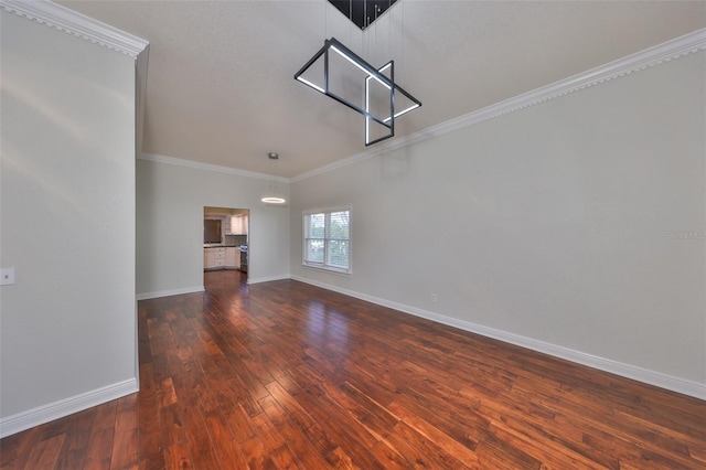 spare room featuring ornamental molding, hardwood / wood-style floors, and baseboards