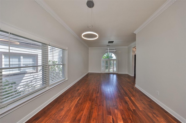 spare room with wood-type flooring, crown molding, and baseboards