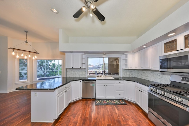 kitchen featuring stainless steel appliances, a peninsula, dark wood-style flooring, a sink, and open shelves