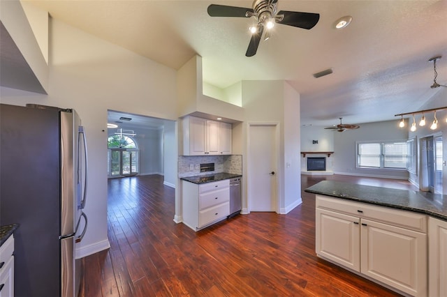 kitchen featuring stainless steel appliances, dark wood-type flooring, visible vents, open floor plan, and a glass covered fireplace